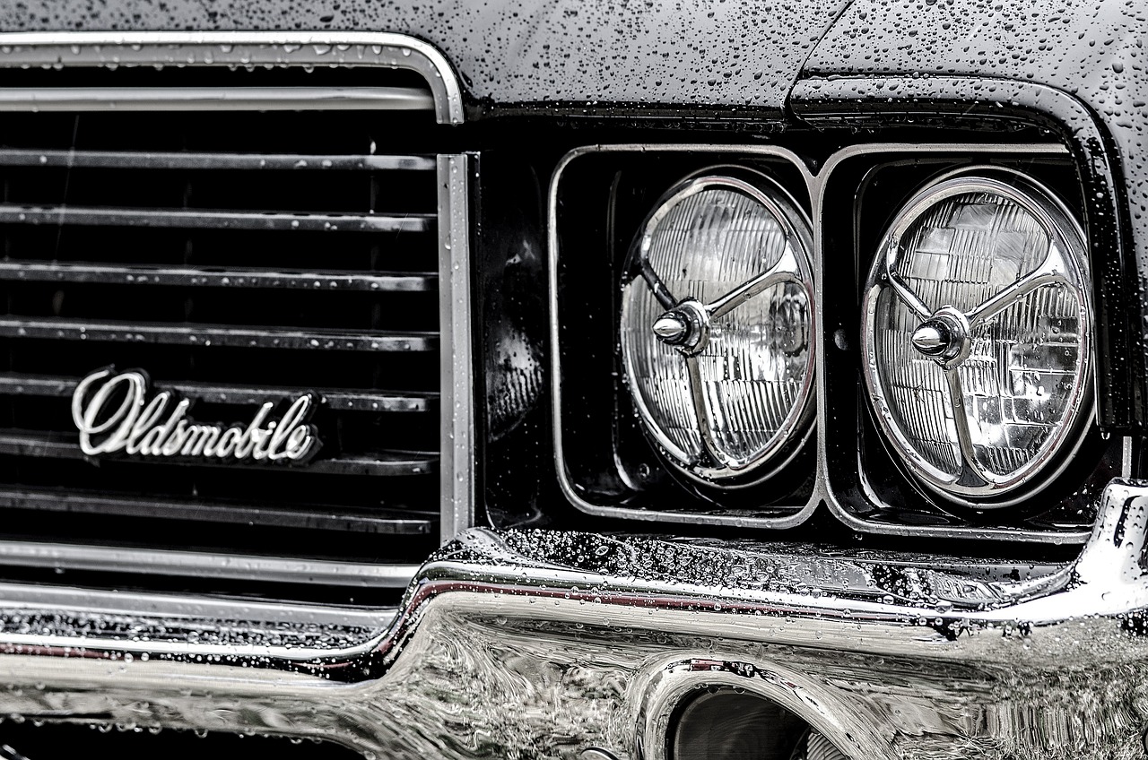 Greyscale headlights and grill of an Oldsmobile