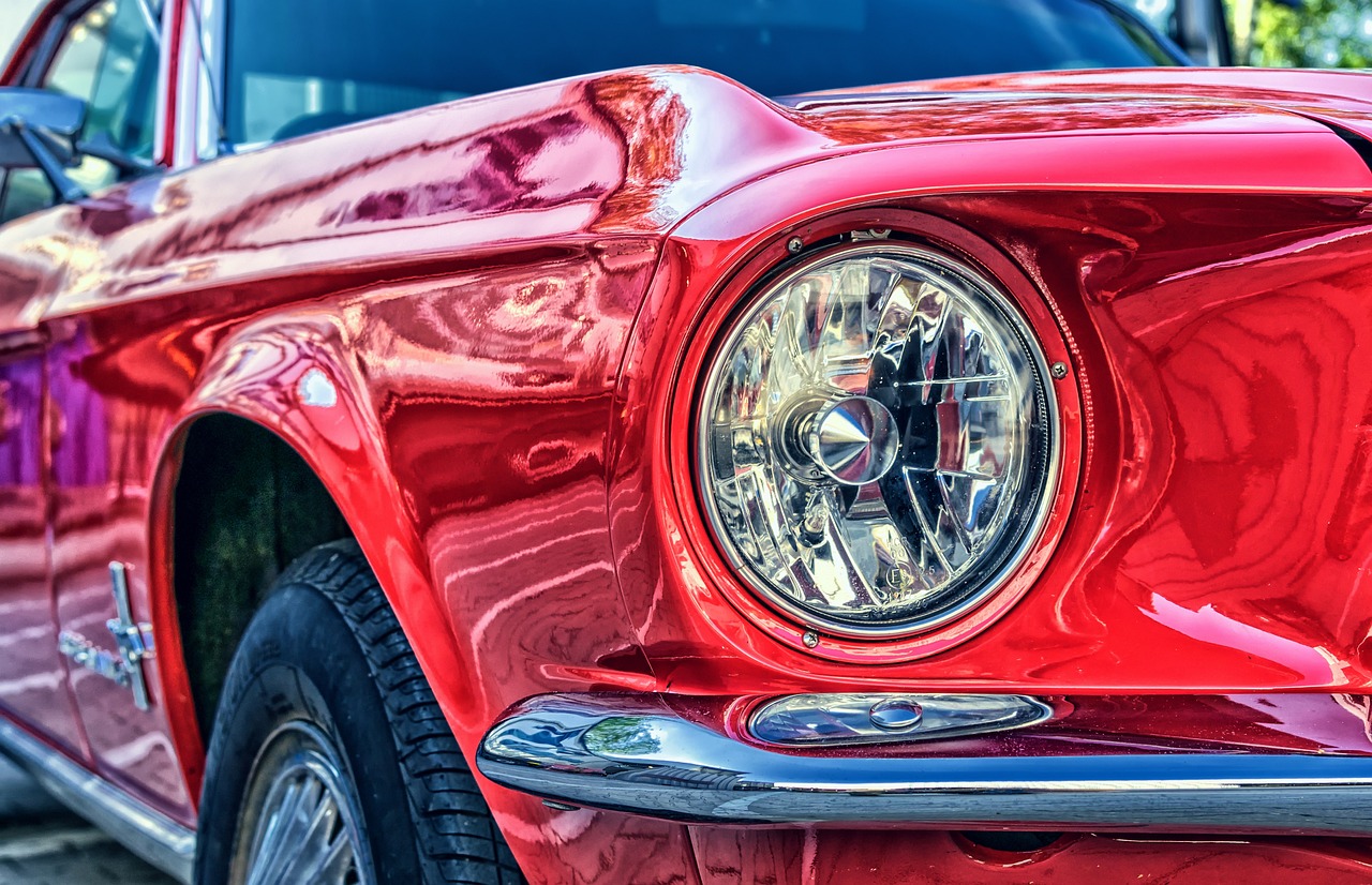 Headlight of a classic red Ford Mustang