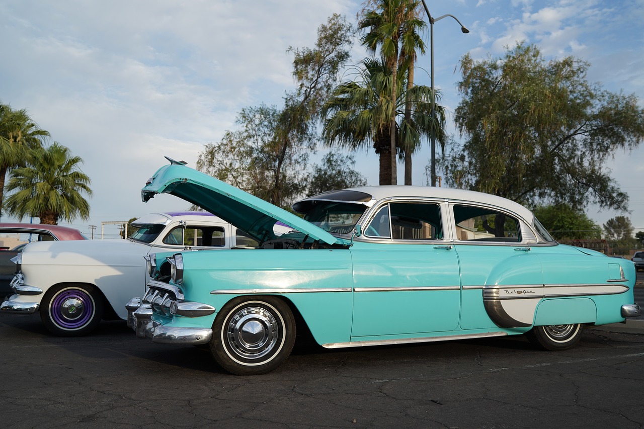 Mint green chevy bel-air with open hood in front of palm trees